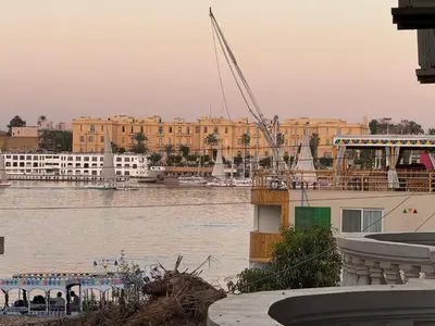 a boat in a body of water with buildings at Soliman Nile View in Luxor