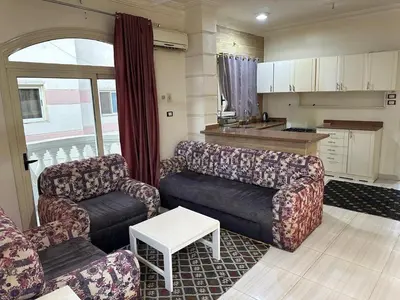 a living room with two couches and a kitchen at Soliman Nile View in Luxor