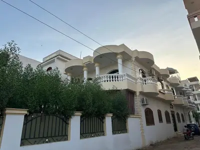 a large white building with a fence at Soliman Nile View in Luxor