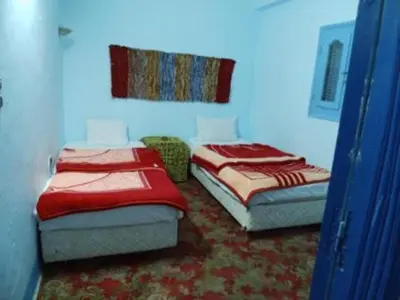 two twin beds in a room withthritisthritisthritisthritisthritisthritisthritisthritisthritis at Bob Marley House Sherief Hotel Luxor in Luxor