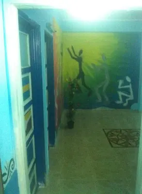 a hallway with a painting of a person on the wall at Bob Marley House Sherief Hotel Luxor in Luxor