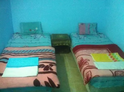 two beds sitting next to each other in a room at Bob Marley House Sherief Hotel Luxor in Luxor