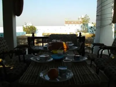 a table with plates of food sitting on a patio at Bob Marley House Sherief Hotel Luxor in Luxor