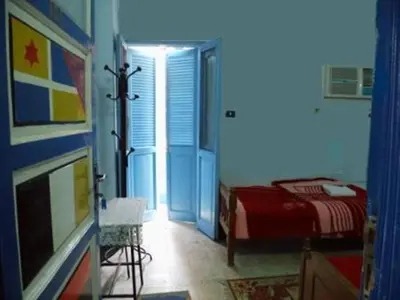 a room with a bedroom with a bed and a window at Bob Marley House Sherief Hotel Luxor in Luxor