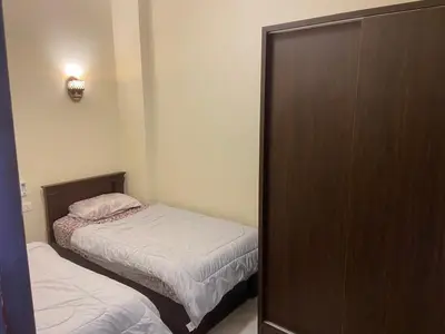 a small bedroom with two beds and a closet at Bahga Palace 1 Residential Apartments in Hurghada