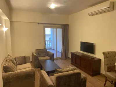a living room with a tv and a couch and chairs at Bahga Palace 2 Residential Apartments in Hurghada