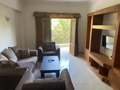 a living room with couches and a television and a table at Bahga Palace 3 Residential Apartments in Hurghada