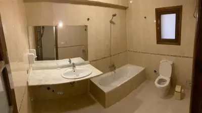 a bathroom with a sink and a tub and a toilet at Bahga Palace 3 Residential Apartments in Hurghada