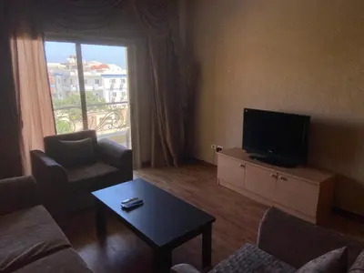 a living room with a tv and a couch and a table at Bahga Palace 3 Residential Apartments in Hurghada