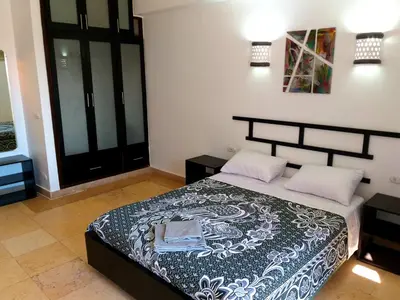 a bedroom with a bed with a black and white bedspread at Apartments in Almaz Plaza in Hurghada