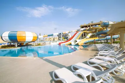 a water park with a water slide and chairs at Stella Gardens Resort & Spa, Makadi Bay in Hurghada