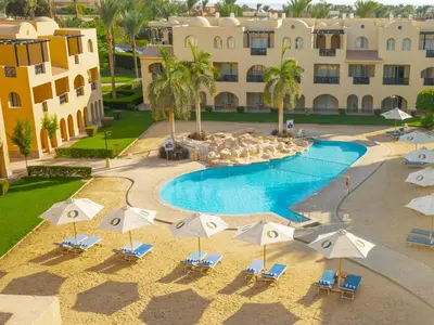 an aerial view of a resort pool with chairs and umbrellas at Stella Gardens Resort & Spa, Makadi Bay in Hurghada
