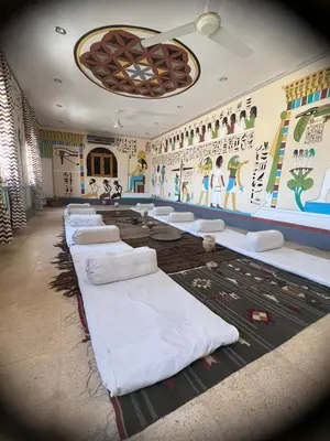 a room with many white pillows on the floor at Janat Elsahara Hotel in Luxor