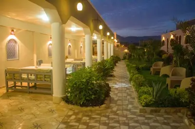 a building with a patio with tables and chairs at Janat Elsahara Hotel in Luxor