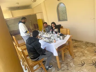 a group of people sitting around a table at Janat Elsahara Hotel in Luxor