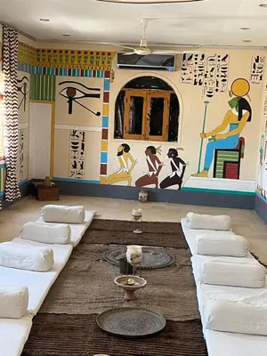 a room with couches and a mural on the wall at Janat Elsahara Hotel in Luxor