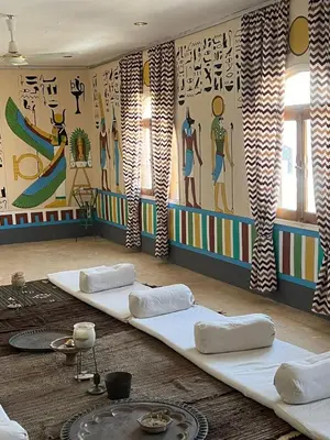 a room with two white pillows and a mural at Janat Elsahara Hotel in Luxor