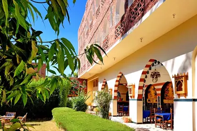a courtyard of a building with tables and chairs at Hotel Sheherazade Luxor in Luxor