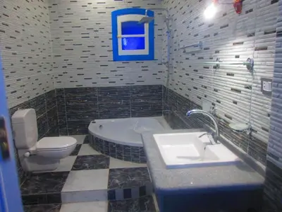 a bathroom with a tub and a sink and a toilet at Moon Valley Apartments in Luxor