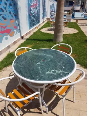 a table with two chairs and a table with a glass top at Moon Valley Apartments in Luxor