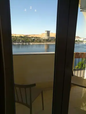 a balcony with a table and a view of the water at Philae Hotel Aswan in Aswan