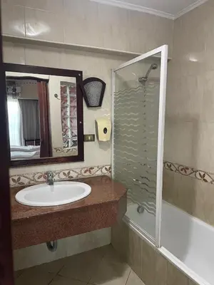 a bathroom with a sink and a shower with a mirror at Philae Hotel Aswan in Aswan