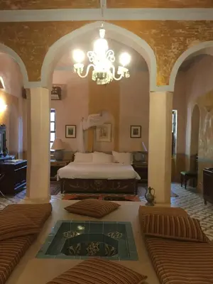 a large bedroom with a bed and a chandelier at Al Moudira Hotel in Luxor