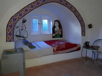 a bedroom with a bed with a painting on the wall at Al Baeirat Hotel in Luxor