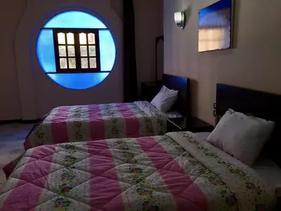 a bedroom with two beds and a window at Sunflower Guest House Luxor West Bank in Luxor