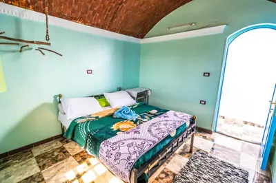 a bedroom with a bed in a room with blue walls at Nubian Paradise in Aswan