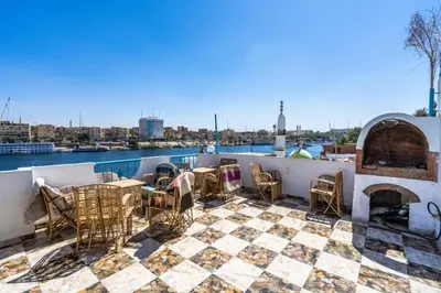 a patio with a table and chairs on a roof at Nubian Paradise in Aswan