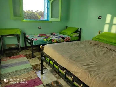 a bedroom with two beds and a window at Nubian Paradise in Aswan