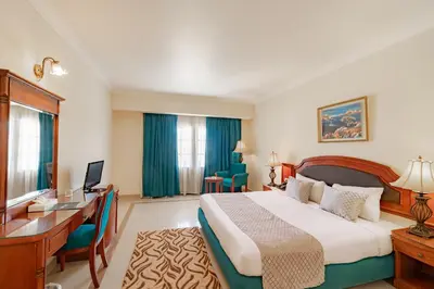 a hotel room with a large bed and a desk at Coral Hills Resort & SPA in Quseir