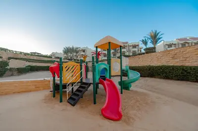 a playground in the sand with a slide at Coral Hills Resort & SPA in Quseir