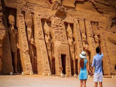a man and a woman standing in front of a temple at Nile Cruises 5 Stars From From Aswan 03 Nights -From Luxor 04 Nights in Luxor