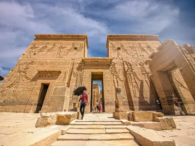 a person with an umbrella standing in front of a building at Nile Cruises 5 Stars From From Aswan 03 Nights -From Luxor 04 Nights in Luxor
