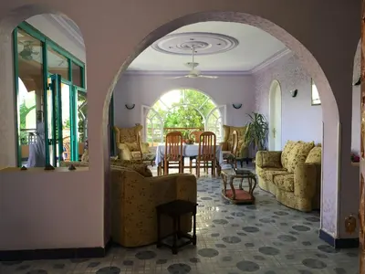 an archway in a living room with a table and chairs at Al Gezera Apartments in Luxor