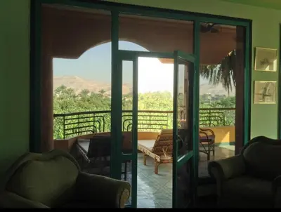 a living room with a door open to a balcony at Al Gezera Apartments in Luxor