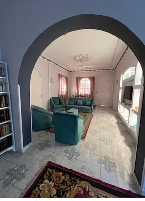 a living room with green furniture and an archway at Al Gezera Apartments in Luxor
