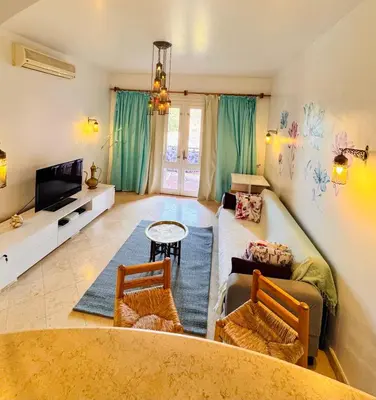 a living room with a couch and a tv at South Marina El Gouna 1 BR in Hurghada