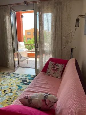 a bedroom with a pink bed with a sliding glass door at South Marina El Gouna 1 BR in Hurghada
