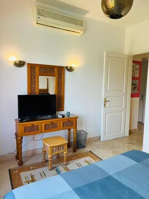 a bedroom with a desk with a tv and a mirror at South Marina El Gouna 1 BR in Hurghada
