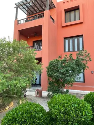 an orange building with trees in front of it at South Marina El Gouna 1 BR in Hurghada