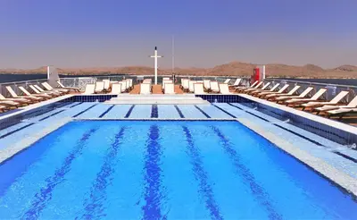 a swimming pool with chairs and a cross on a cruise ship at Steigenberger Legacy Nile Cruise - Every Monday 07 & 04 Nights from Luxor - Every Friday 03 Nights from Aswan in Luxor
