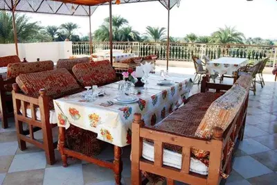 a table and chairs on a patio with an umbrella at Leyla Eco Resort in Luxor