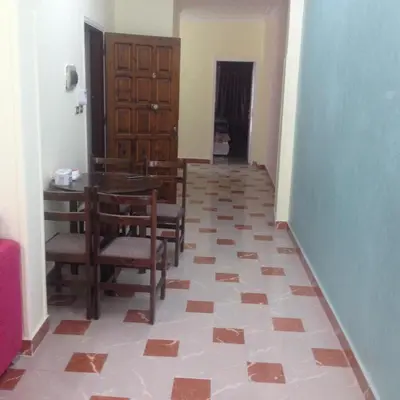 a dining room with a table and chairs on a tile floor at Sweet Home Flat 2- 24 Hour open in Hurghada