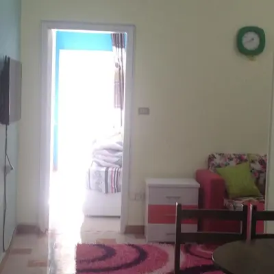 a living room with a couch and a clock on the wall at Sweet Home Flat 2- 24 Hour open in Hurghada