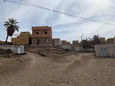 a group of buildings on a dirt road at King Nubian House in Aswan