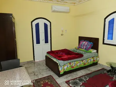 a bedroom with a bed and a white door at King Nubian House in Aswan