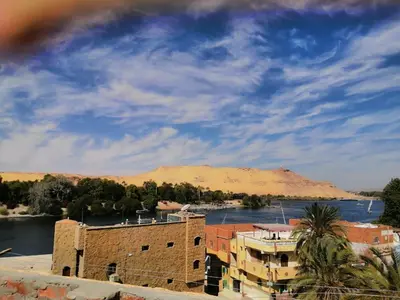a view of a river and a building and a mountain at King Nubian House in Aswan